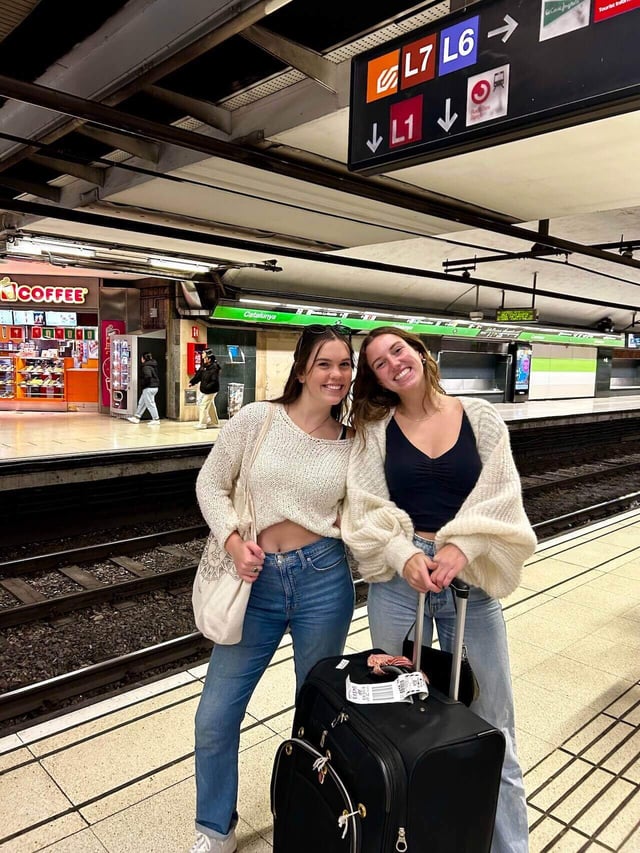 Two college students smiling inside a metro station