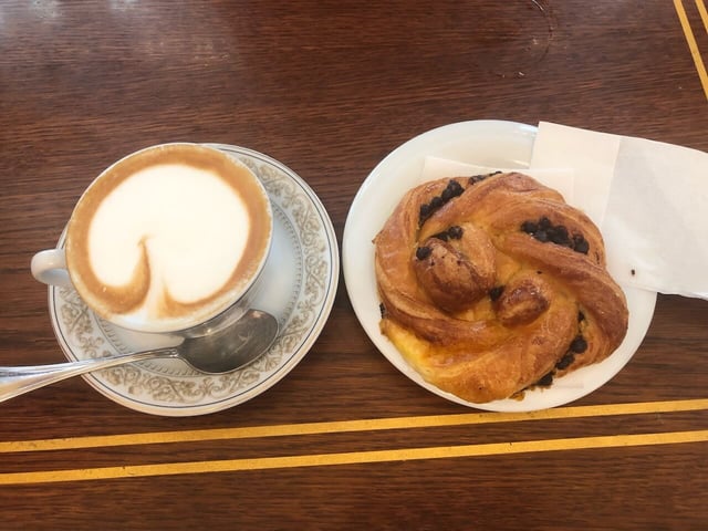 A chocolate croissant and cappuccino