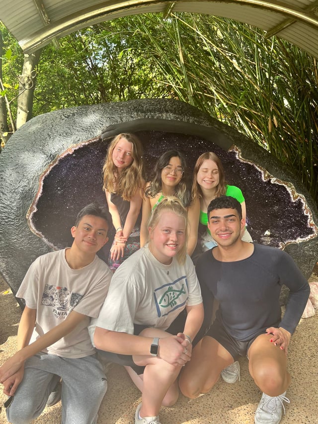 A group photo of 6 friends in front of a big crystal