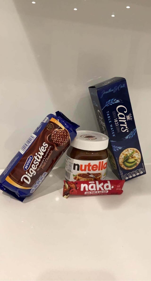 A variety of snacks like chocolate digestives, crackers, and Nutella